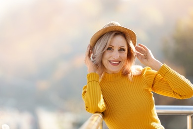 Portrait of happy mature woman on balcony, outdoors