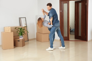 Couple dancing near moving boxes in their new house