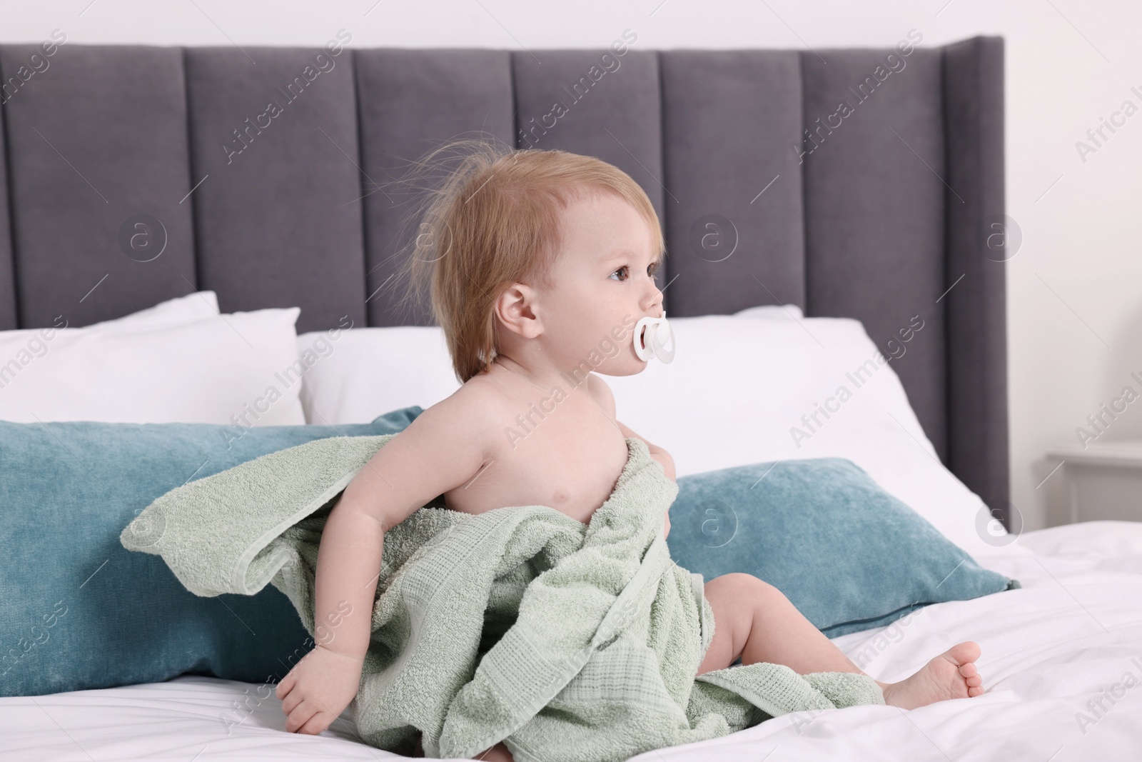 Photo of Cute little baby with towel after bathing on bed