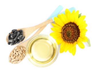 Photo of Sunflower, oil in glass bowl and seeds on white background, top view