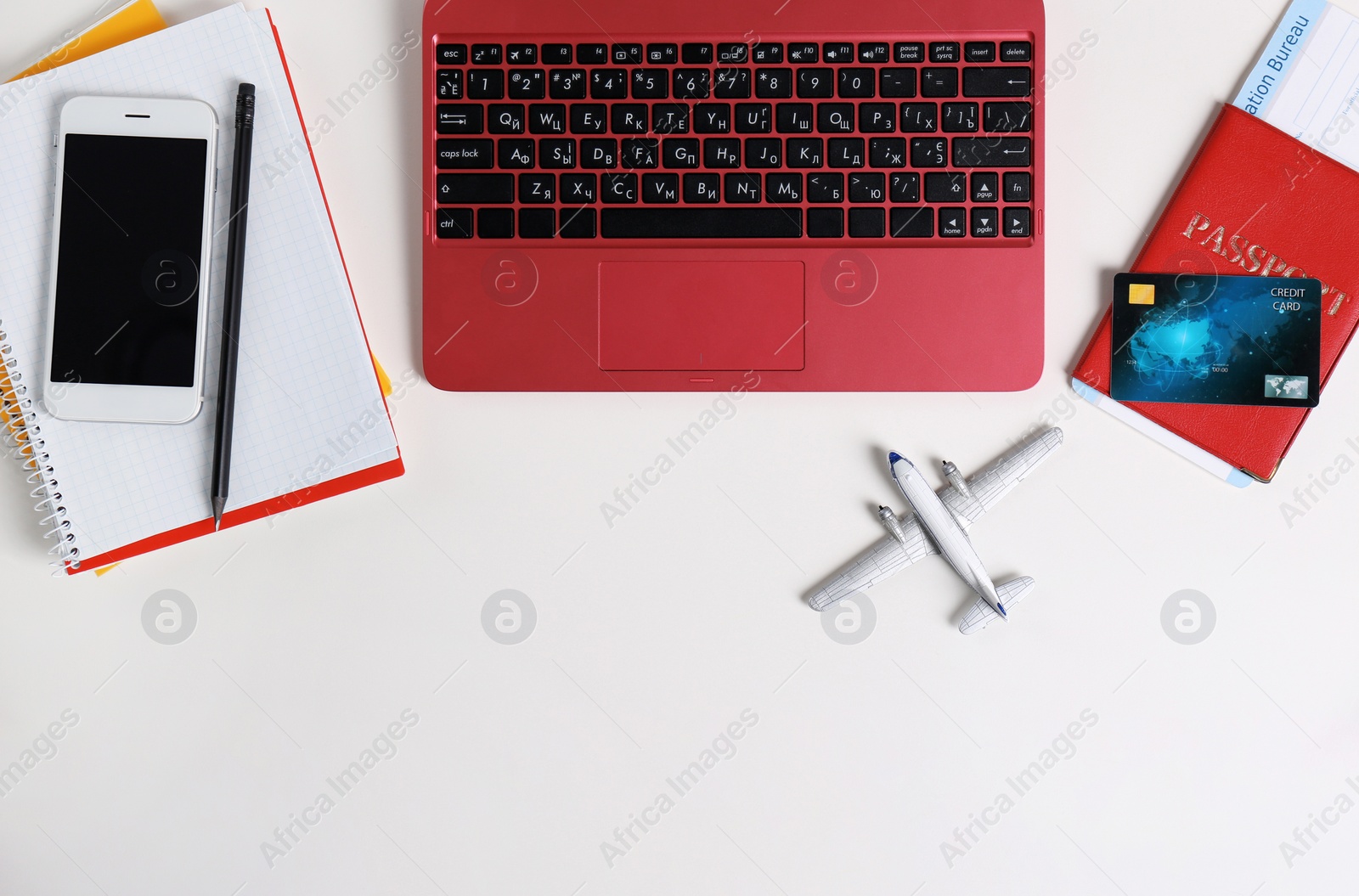 Photo of Flat lay composition with laptop and plane model on white background, space for text. Travel agency