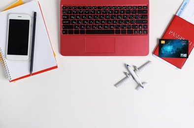 Photo of Flat lay composition with laptop and plane model on white background, space for text. Travel agency