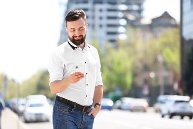 Portrait of young man with smartphone outdoors