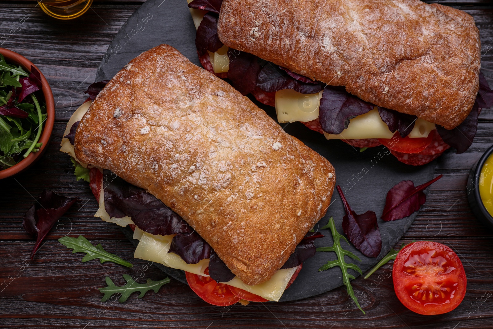 Photo of Delicious sandwiches with tasty filling and ingredients on wooden table, flat lay