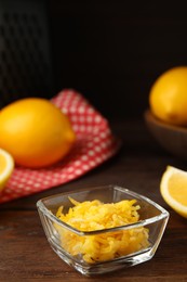 Photo of Grated lemon zest and fresh fruits on wooden table