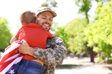 Photo of American soldier with his son outdoors. Military service