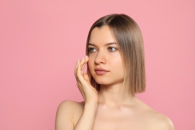 Photo of Young woman with perfect skin on pink background