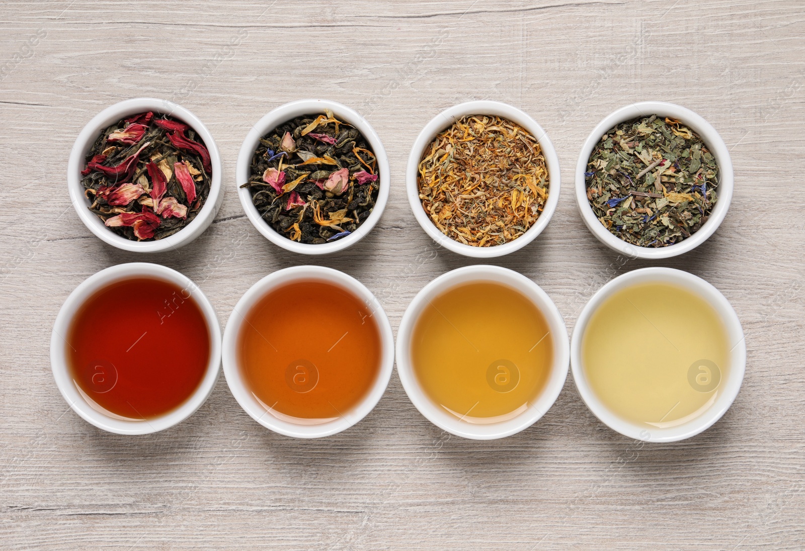 Photo of Flat lay composition with different freshly brewed teas and dry leaves on wooden table