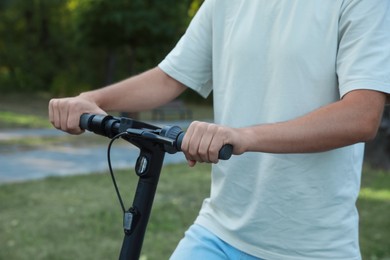 Man riding modern electric kick scooter outdoors, closeup