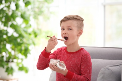 Little boy with yogurt indoors