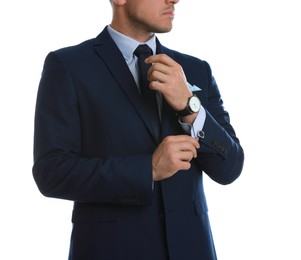 Photo of Stylish man putting on cufflink against white background, closeup