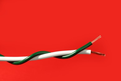 Photo of Two different electrical wires on red background. Space for text