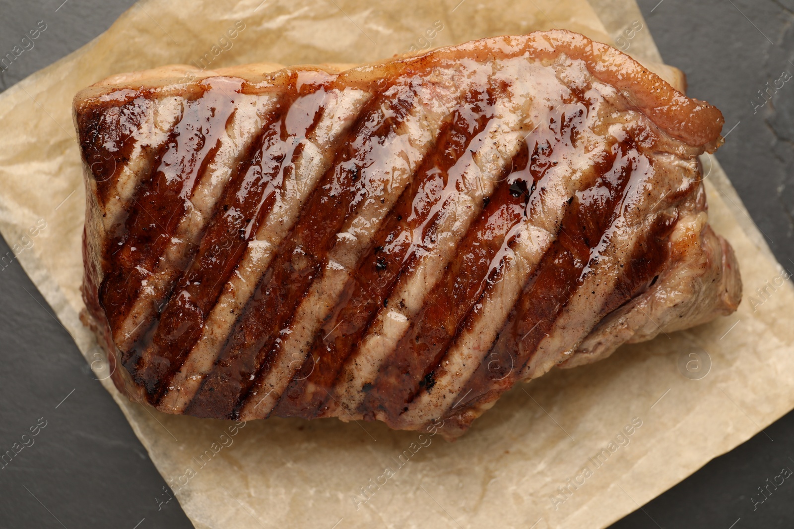 Photo of Delicious grilled beef steak on grey table, top view