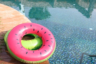 Photo of Inflatable rings on wooden deck near swimming pool. Luxury resort