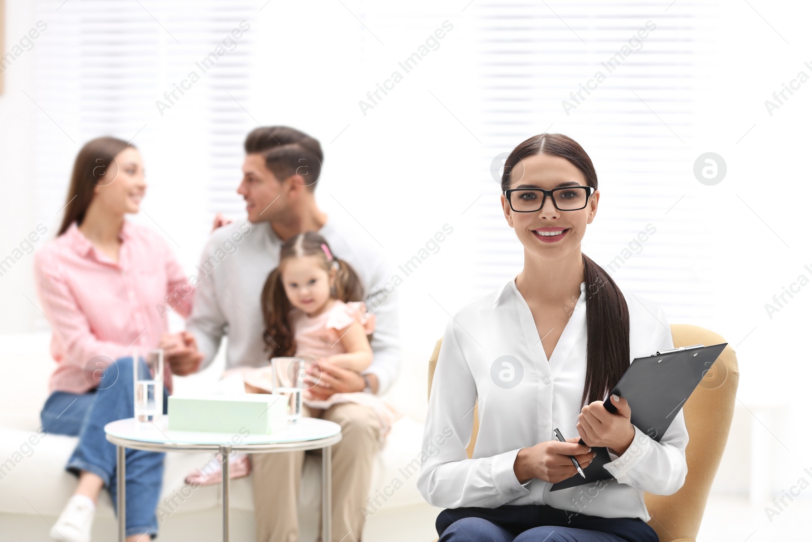 Photo of Professional psychologist and happy family in office