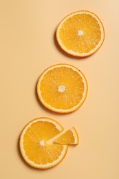 Slices of juicy orange on beige background, flat lay
