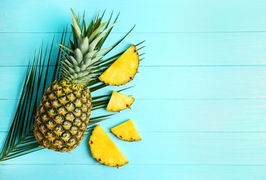 Photo of Fresh pineapples on color wooden background