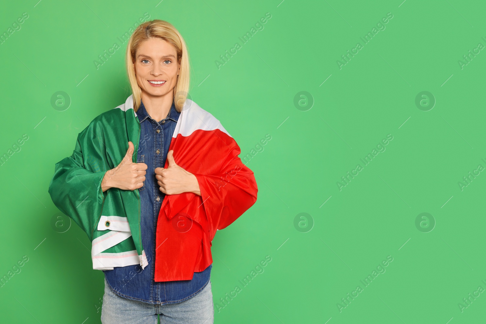 Photo of Woman with flag of Italy showing thumbs up on green background, space for text
