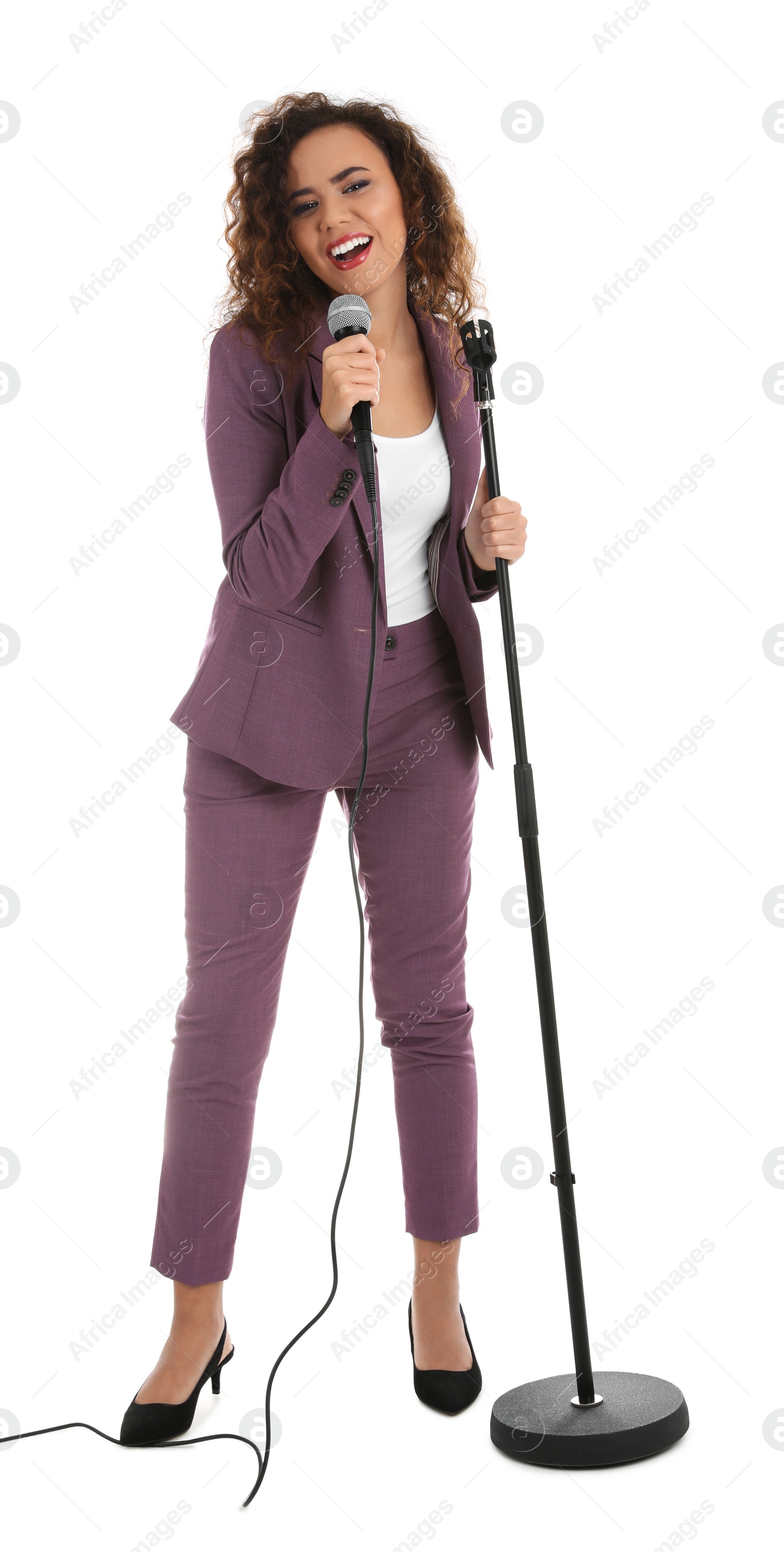 Photo of Curly African-American woman in suit singing with microphone on white background