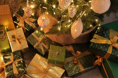 Photo of Many different gifts under Christmas tree indoors, above view