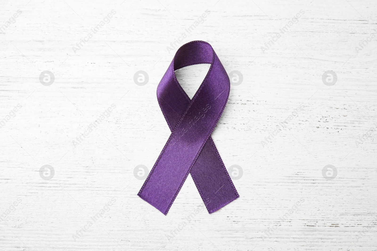 Photo of Purple ribbon on white wooden background, top view. Domestic violence awareness