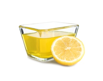 Photo of Piece of lemon and tasty jelly dessert in glass bowl on white background