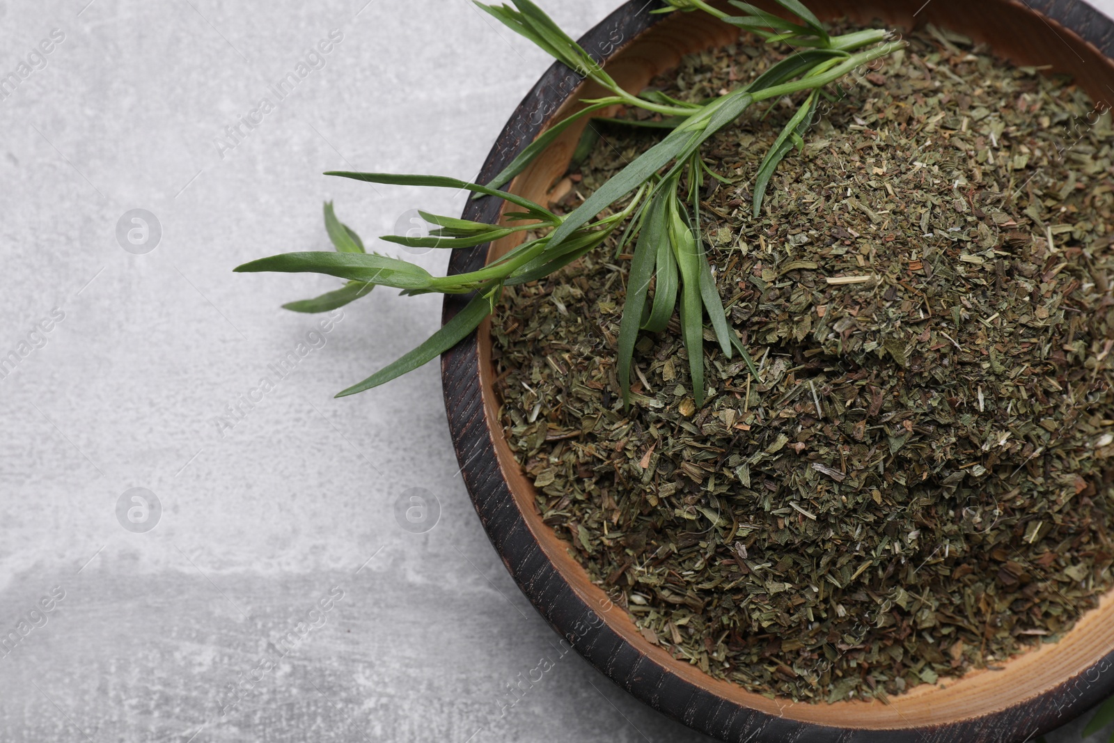 Photo of Dry and fresh tarragon on light gray textured table, top view. Space for text