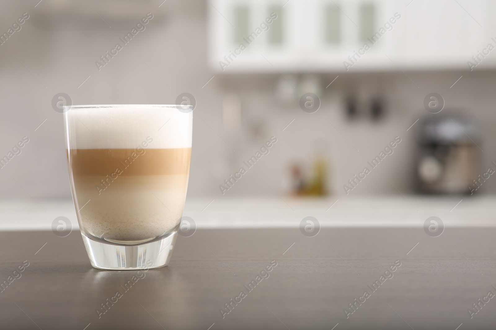 Photo of Glass of aromatic coffee on countertop in kitchen, space for text