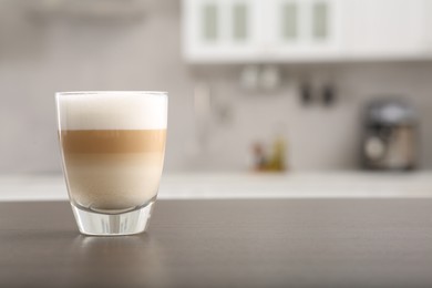 Glass of aromatic coffee on countertop in kitchen, space for text