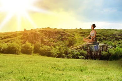 Image of Woman meditating in mountains at sunrise, space for text