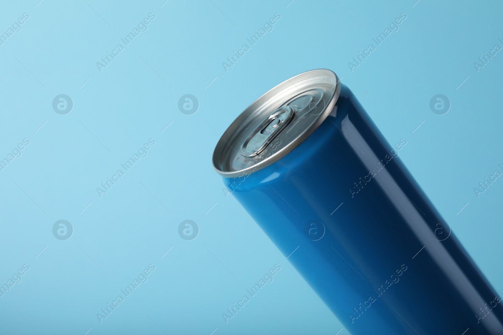 Photo of Can of energy drink on light blue background, closeup. Space for text