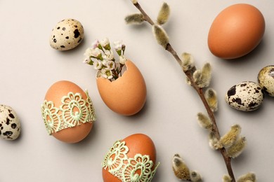 Photo of Flat lay composition with eggs and natural decor on light grey background. Happy Easter