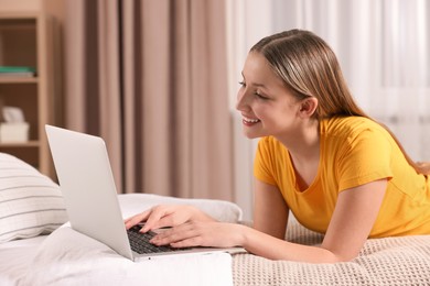 Photo of Online learning. Teenage girl with laptop on bed at home