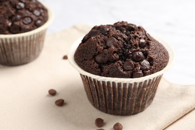Photo of Tasty chocolate muffin on white table, closeup