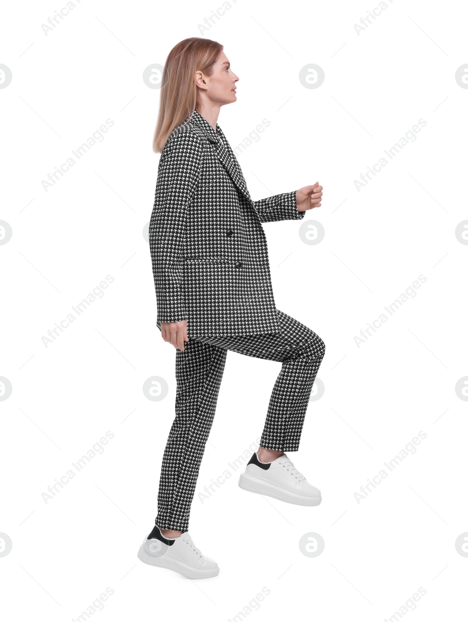 Photo of Beautiful businesswoman in suit walking on white background