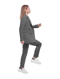 Photo of Beautiful businesswoman in suit walking on white background