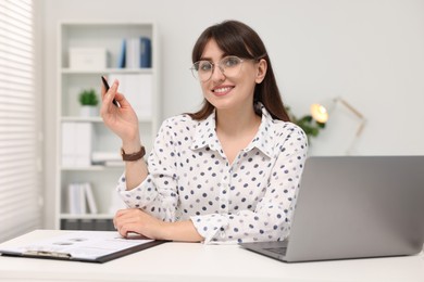 Photo of Portrait of smiling secretary at table in office