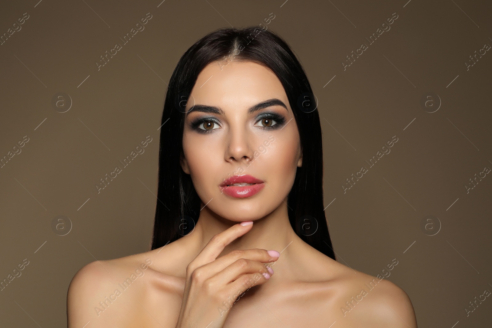 Photo of Beautiful young woman with evening makeup on brown background. Eye shadow product