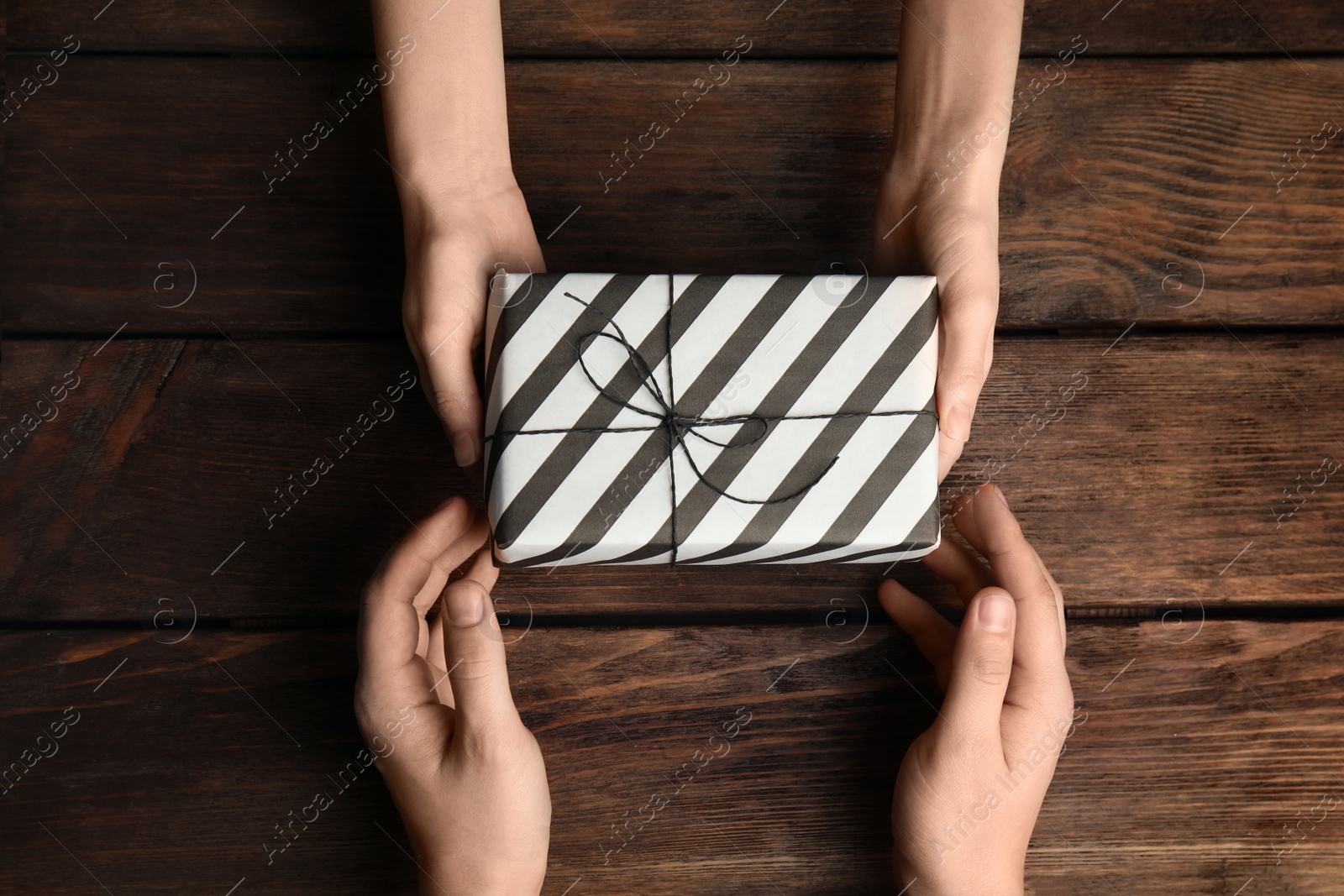 Photo of Daughter giving present to her dad over wooden table, top view. Happy father's day