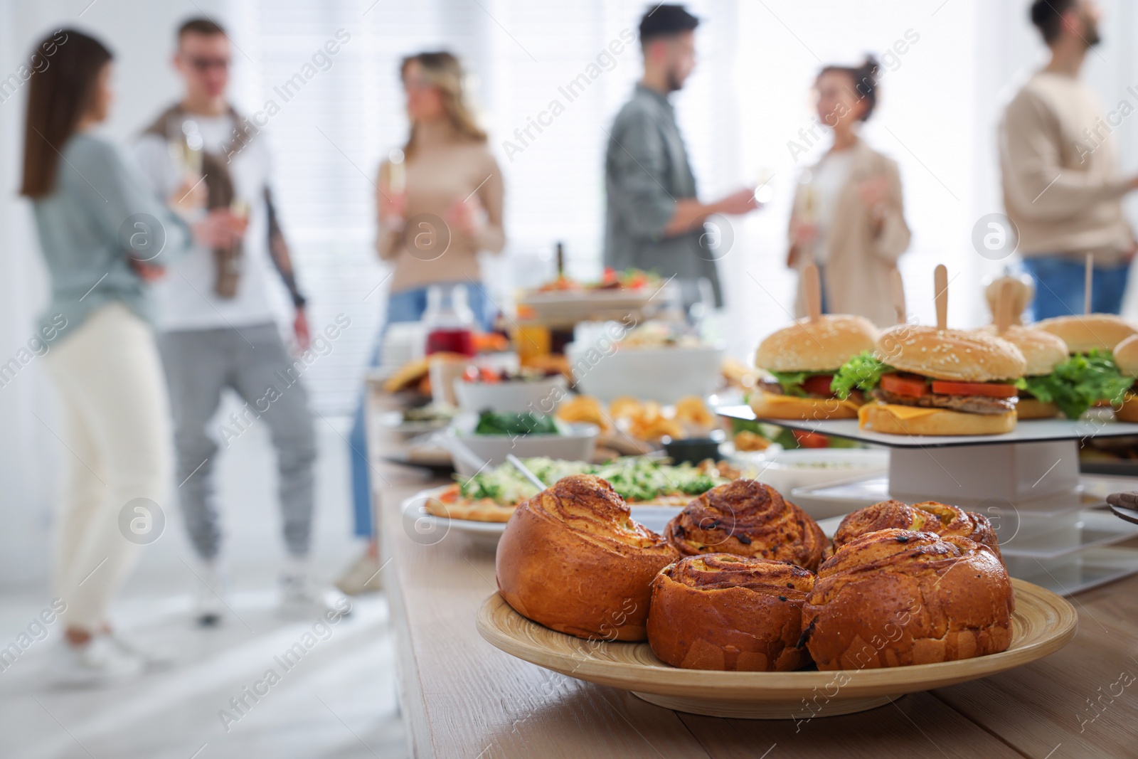 Photo of Brunch table setting with different delicious food	and blurred view of people on background