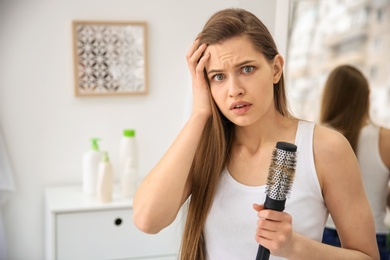 Photo of Young woman with hair loss problem indoors