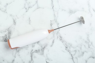 Photo of Milk frother wand on white marble table, top view