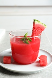 Photo of Summer watermelon drink with mint in glass served on table