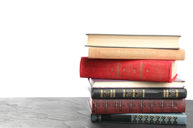 Photo of Stack of old vintage books on grey stone table against white background