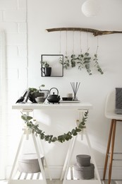 Stylish room decorated with beautiful green eucalyptus branches