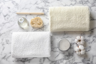 Photo of Flat lay composition with spa cosmetics and towel on light background