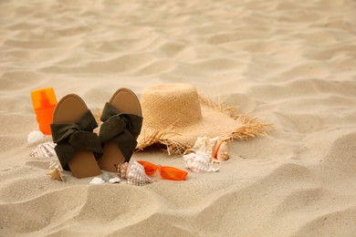 Different beach objects on sand, space for text