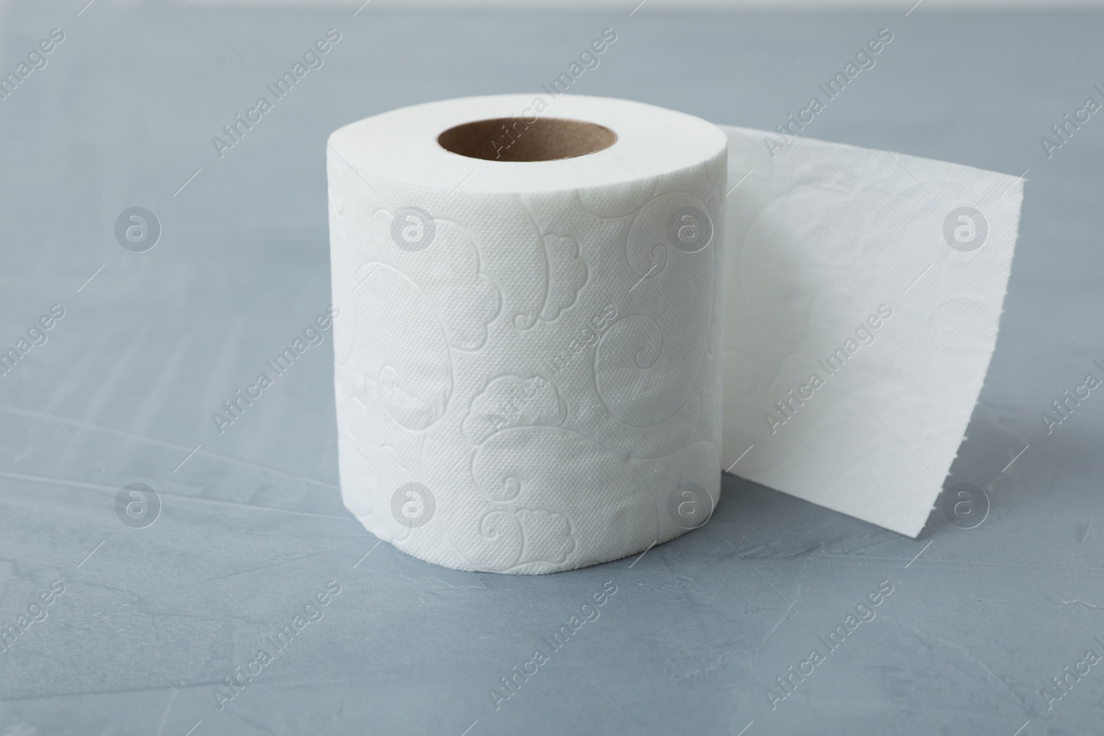 Photo of Soft toilet paper roll on gray table