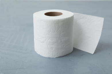 Photo of Soft toilet paper roll on gray table