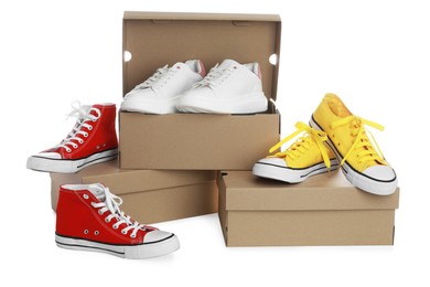 Different stylish shoes and cardboard boxes on white background